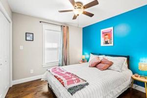 a bedroom with blue walls and a bed with a ceiling fan at Harvey House - Tranquil Lincoln Park Extended Stay in Knoxville
