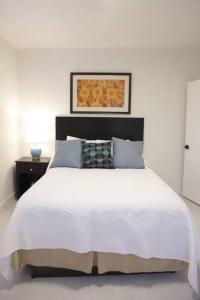een slaapkamer met een wit bed met een zwart hoofdeinde bij Apt 3 Miami Designer Apartment in the Upper East-Side in Miami