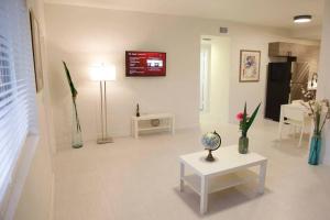 een woonkamer met een tafel en een tv aan de muur bij Apt 3 Miami Designer Apartment in the Upper East-Side in Miami
