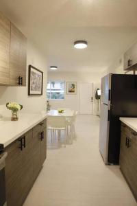 een keuken met een koelkast en een tafel. bij Apt 3 Miami Designer Apartment in the Upper East-Side in Miami