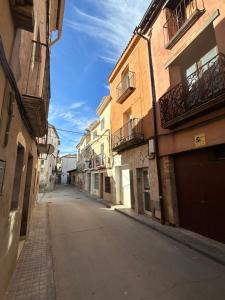 an empty street in an alley between two buildings at Los Meandros in Sástago