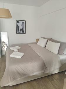 um quarto branco com uma cama grande e almofadas brancas em Cabildo Complete Suite em Buenos Aires