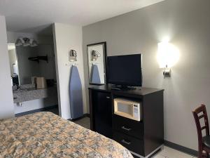 1 dormitorio con cama y vestidor con TV en Deerfield Inn, en Xenia