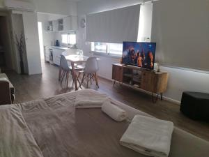 1 dormitorio con 1 cama, TV y mesa en Cabildo Complete Suite en Buenos Aires