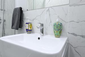 a bathroom with a sink with two bottles on it at 1 BEDROOM FLAT IN WOOD GREEN PICCADILLY LINE in London +22 photos