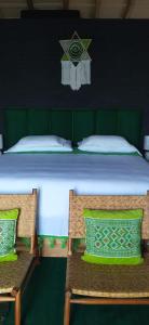 a bedroom with a large bed with two chairs at Hotel Bendita Luna Salchi in Cuatunalco