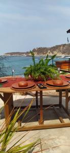 a wooden table with plants on it next to the water at Hotel Bendita Luna Salchi in Cuatunalco