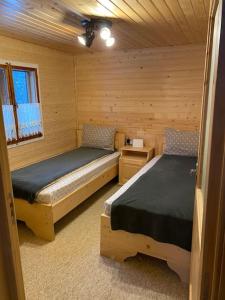 a bedroom with two beds in a log cabin at Mountain View Tiny House in Lacu Rosu
