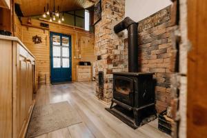 a wood stove in a room with a brick wall at Mountain View Tiny House in Lacu Rosu