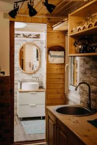 una piccola cucina con lavandino e specchio di Mountain View Tiny House a Lacu Rosu