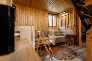 Sala de estar con sofá y silla en una cabaña en Mountain View Tiny House en Lacu Rosu