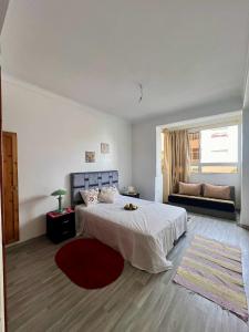 um quarto branco com uma cama grande e um sofá em Appartement Lallaty em Rabat