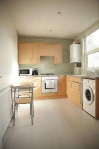 a kitchen with a table and a stove and a dishwasher at 2 New bed flat in hammersmith in London