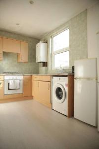 a kitchen with a refrigerator and a washing machine at 2 New bed flat in hammersmith in London