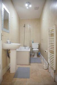 a bathroom with a sink and a toilet and a bath tub at 2 New bed flat in hammersmith in London