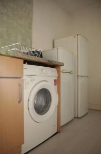 a kitchen with a washing machine and two refrigerators at 2 New bed flat in hammersmith in London