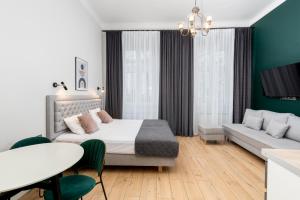 a bedroom with a bed and a couch and a table at Wawel Apartments - Old Town in Krakow