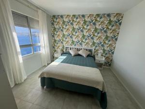 a bedroom with a large bed with a wall at Un lujoso duplex en Radazul en primera linea de playa y con parking propio in Radazul