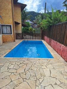 a small blue swimming pool with a stone patio at Sobrado bem localizado em Praia de Boiçucanga in São Sebastião