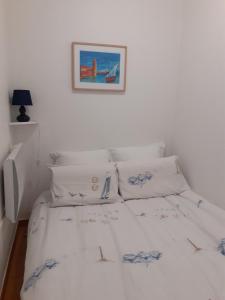 a bedroom with two beds and a picture on the wall at Appartement Canet Sud Jardin et parking in Canet-en-Roussillon