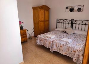 a bedroom with a bed with a wooden dresser and a cabinet at Retiro del Bullaque in El Robledo