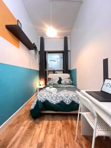 a bedroom with a bed and a desk with a laptop at Relaxing Closed Partition Room in Tecom Near Metro in Dubai