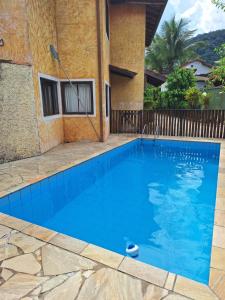 a large blue swimming pool in front of a house at Sobrado bem localizado em Praia de Boiçucanga in São Sebastião