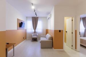 um quarto com um sofá, uma cama e uma mesa em Hotel Le Village Distributed By Intercity em Joinville