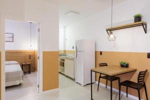 a kitchen and dining room with a table and a bed at Le Village Flats e Hotel in Joinville +27 photos