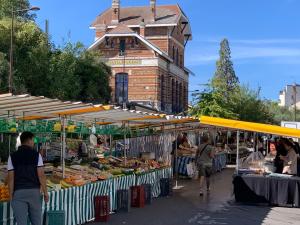 a market with fruits and vegetables in front of a building at La Résidence Alpha Viroflay 102 - 1 chambre - 2 pers in Viroflay