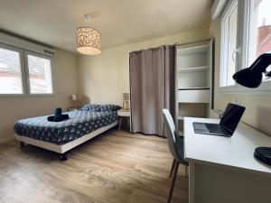 een slaapkamer met een bed en een bureau met een laptop bij * Le Cocon * Centre-ville Douai-500m place d'Armes in Douai