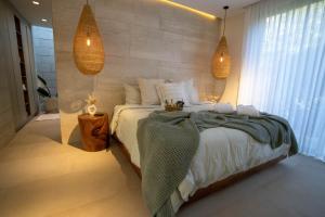 ein Schlafzimmer mit einem großen Bett und zwei Hängelampen in der Unterkunft Zavura Studio Tamarindo in Tieso