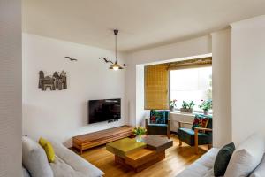 a living room with a couch and a table at La Casa Di Fiori Stylish Holiday Home in Plataniás