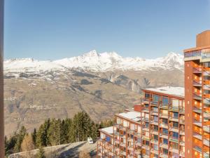 un hôtel avec des montagnes enneigées en arrière-plan dans l'établissement Studio Les Arcs 1800, 1 pièce, 3 personnes - FR-1-346-499, à Arc 1800