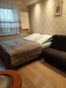 a bed and a couch in a room at Willa Kamako in Międzyzdroje