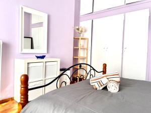 a bedroom with a bed with a mirror and a dresser at Fenia's Apartment in Athens