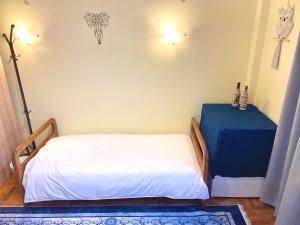 Un pequeño dormitorio con una cama y una mesa azul en Fenia's Apartment, en Atenas