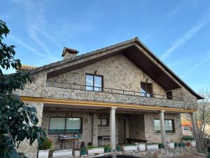 a stone house with a balcony on top of it at Chalet As Mimosas in Cangas de Morrazo