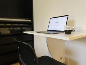 um computador portátil sentado numa secretária com uma chávena de café em L'aparté - Centre ville Lens - Gare em Lens
