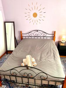 a bedroom with a bed with a sun on the wall at Fenia's Apartment in Athens