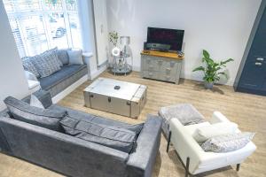 a living room with a couch and chairs and a tv at Jalebo in Cleethorpes
