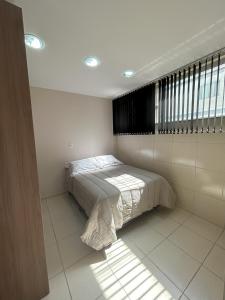 1 dormitorio con 1 cama en una habitación con ventana en Kitnet 02, en Rio Negrinho