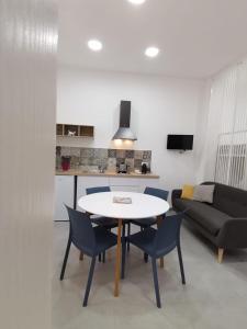 uma sala de estar com uma mesa e cadeiras e um sofá em CasAnna em Castellammare del Golfo