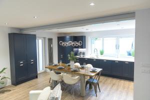 a kitchen with a table and a kitchen with blue cabinets at Jalebo in Cleethorpes