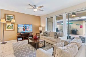 uma sala de estar com um sofá e uma televisão em Townhome with Private Pool, BBQ & FREE Waterpark em Kissimmee