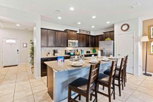 a kitchen with a large island with bar chairs at Townhome with Private Pool, BBQ & FREE Waterpark in Kissimmee