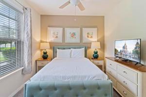 a bedroom with a bed and a flat screen tv at Townhome with Private Pool, BBQ & FREE Waterpark in Kissimmee