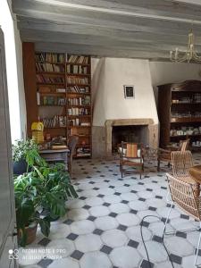 a living room with a fireplace and a room with a floor at La maison Benastre in Saint-Étienne-de-Corcoué