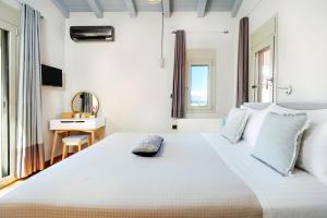 a bedroom with a large white bed with a desk at La Casa Di Fiori Stylish Holiday Home in Plataniás