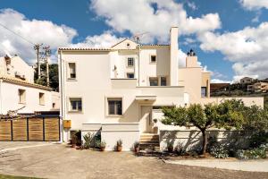 a white house with a gate in front of it at La Casa Di Fiori Stylish Holiday Home in Plataniás